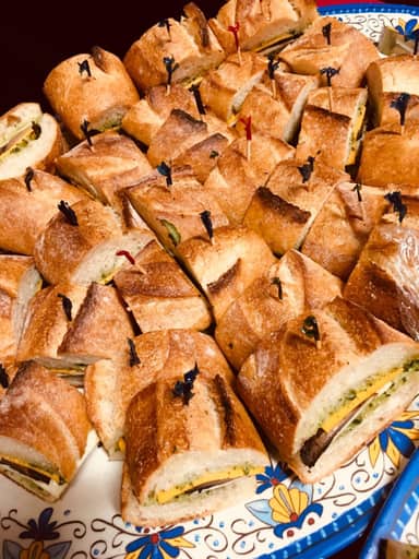 Toasted sandwich squares piled on a patterned platter.